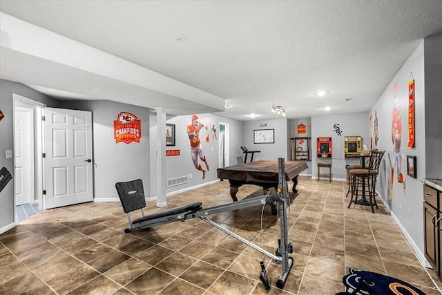 recreation room featuring visible vents, a textured ceiling, baseboards, and tile patterned floors