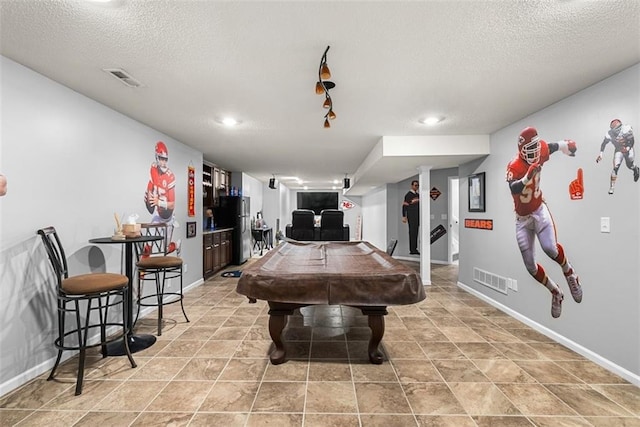 recreation room featuring visible vents, billiards, a textured ceiling, and baseboards
