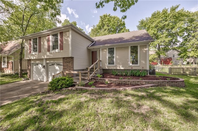 split level home with concrete driveway, an attached garage, and a shingled roof