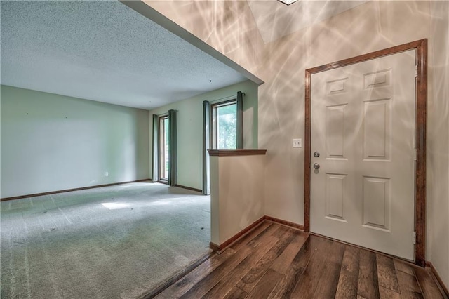 entryway featuring wood finished floors, baseboards, and a textured ceiling
