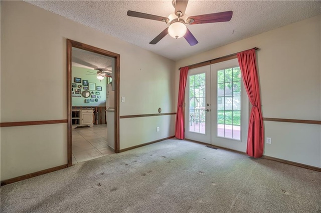 unfurnished room featuring french doors, a textured ceiling, carpet, ceiling fan, and baseboards