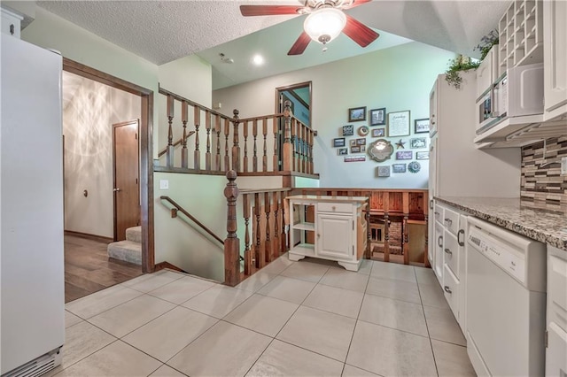 stairs featuring a ceiling fan, a textured ceiling, tile patterned floors, and recessed lighting
