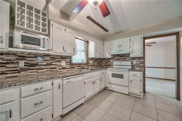 kitchen featuring white appliances, a ceiling fan, a sink, under cabinet range hood, and a textured ceiling