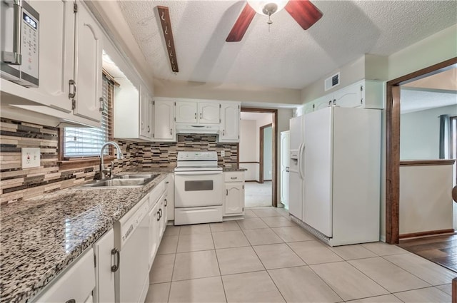 kitchen with white appliances, a sink, a textured ceiling, white cabinetry, and decorative backsplash