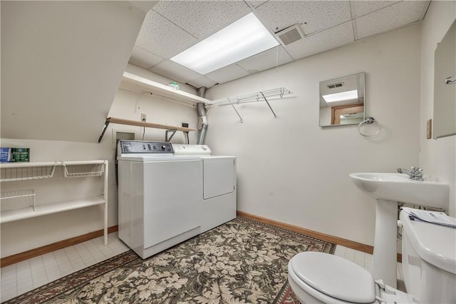 washroom with independent washer and dryer and baseboards