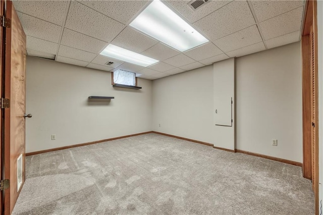 basement featuring carpet floors, a drop ceiling, and baseboards