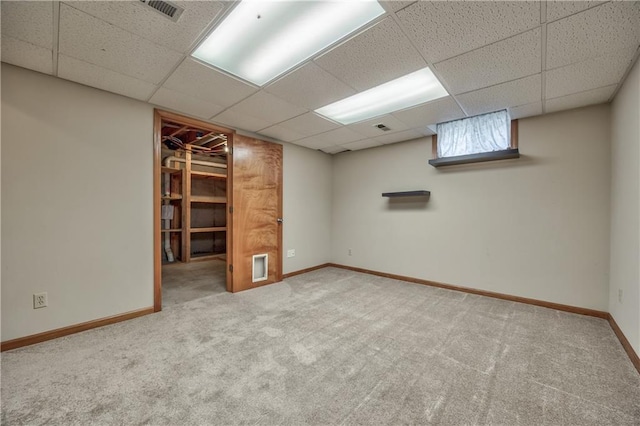 below grade area featuring carpet flooring, a paneled ceiling, and baseboards