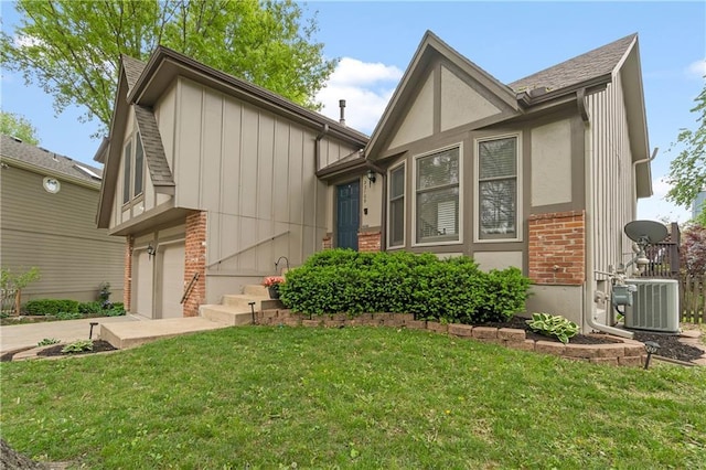 view of front facade with brick siding, central AC unit, driveway, and a front yard