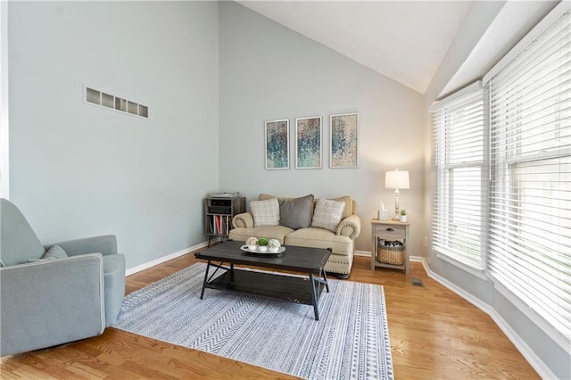 living area with visible vents, light wood-style flooring, baseboards, and plenty of natural light