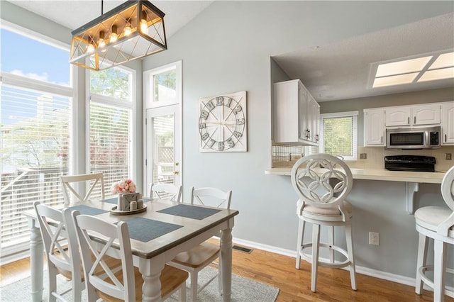 dining room featuring baseboards, visible vents, and light wood-type flooring
