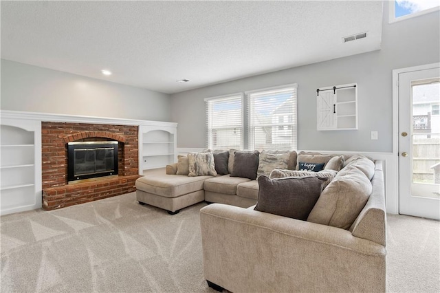 carpeted living room featuring visible vents, plenty of natural light, and built in shelves