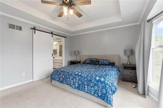 bedroom featuring carpet floors, visible vents, a barn door, and a raised ceiling