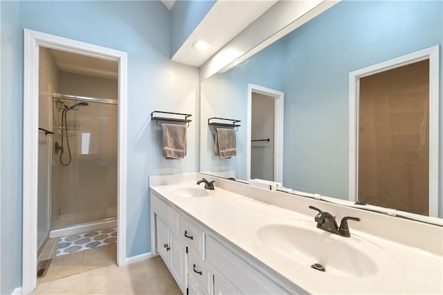 bathroom featuring baseboards, a sink, a stall shower, and double vanity