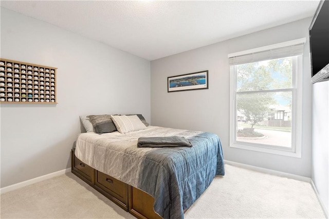 bedroom featuring baseboards and light colored carpet