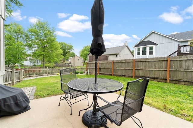 view of patio with area for grilling, a residential view, a fenced backyard, and outdoor dining space
