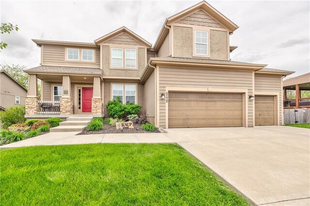 craftsman inspired home with a front lawn, covered porch, stucco siding, an attached garage, and driveway