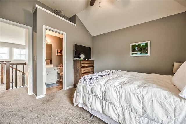 bedroom with carpet flooring, connected bathroom, a ceiling fan, baseboards, and lofted ceiling