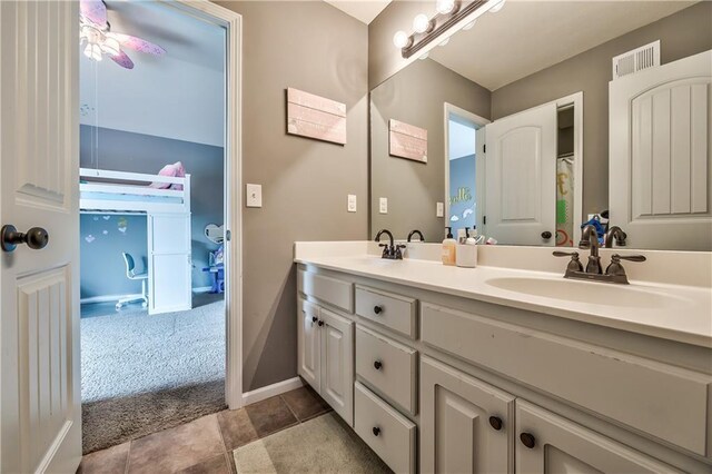 bathroom featuring double vanity, baseboards, visible vents, and a sink