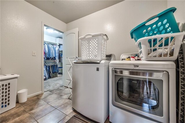 laundry room with washer and dryer and light tile patterned floors