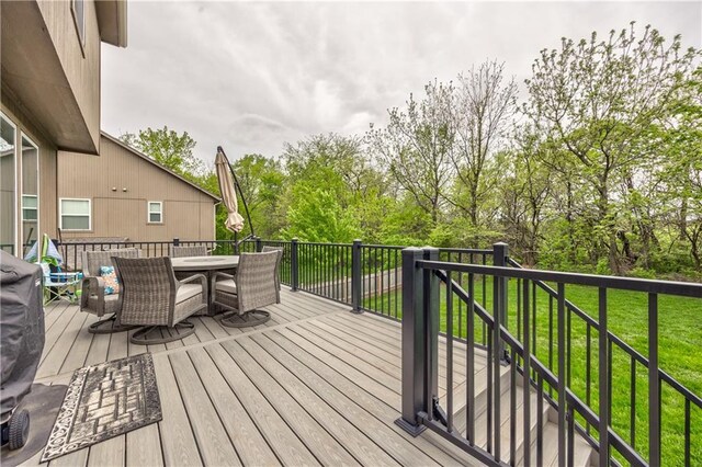 wooden deck with a yard and outdoor dining space