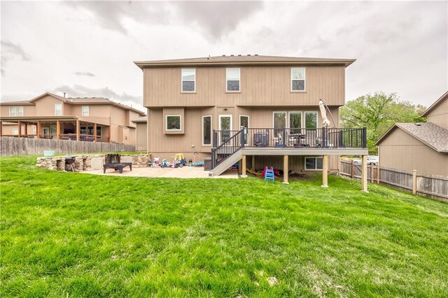 back of property featuring a fire pit, a wooden deck, a fenced backyard, stairs, and a patio area