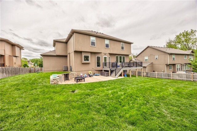 rear view of property with a fenced backyard, a patio area, a deck, and an outdoor fire pit