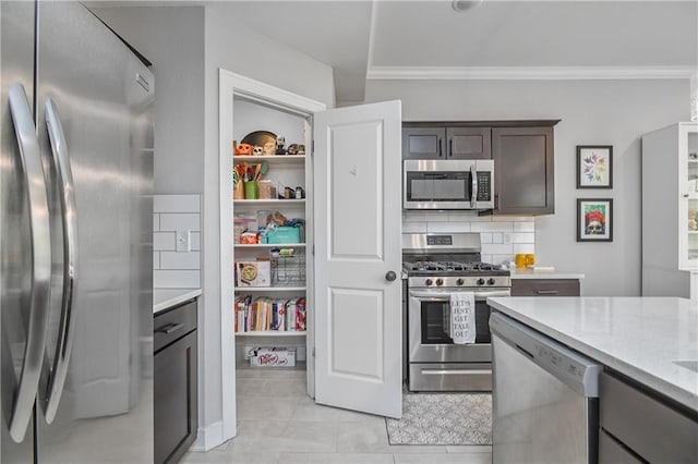 16223 Moon Shot St, Parkville, MO 64152 - kitchen featuring crown molding, dark brown cabinets, appliances with stainless steel finishes, light stone counters, and light tile patterned floors