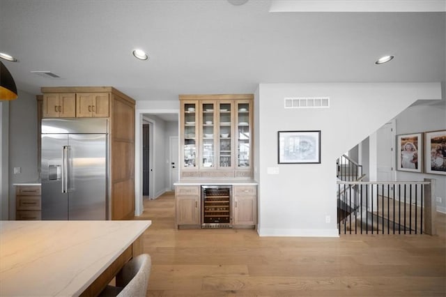 kitchen with visible vents, stainless steel built in refrigerator, light wood finished floors, wine cooler, and recessed lighting