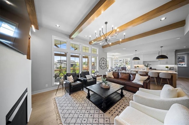 living room with an inviting chandelier, recessed lighting, beamed ceiling, and light wood finished floors