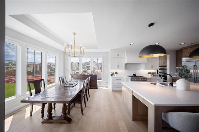 dining room with an inviting chandelier, recessed lighting, light wood-style floors, and plenty of natural light
