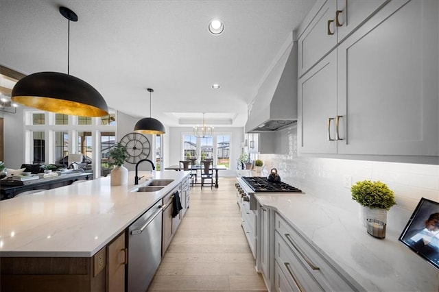 kitchen featuring light stone countertops, light wood-style floors, recessed lighting, a sink, and stainless steel appliances