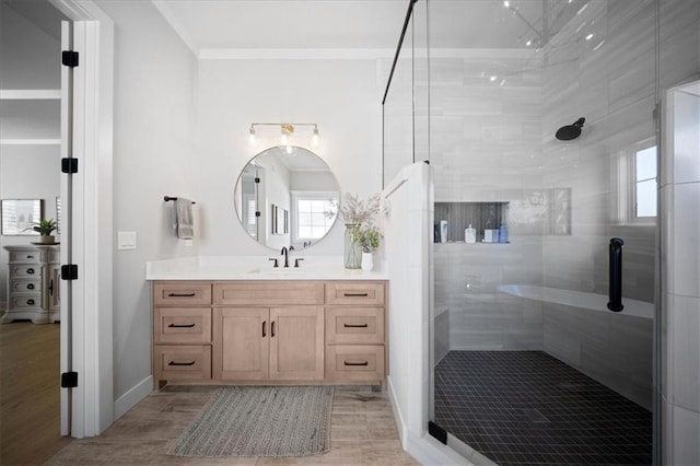 bathroom featuring a tile shower, vanity, baseboards, wood finished floors, and ornamental molding