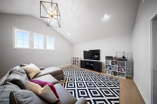 living area with baseboards, wood finished floors, and lofted ceiling