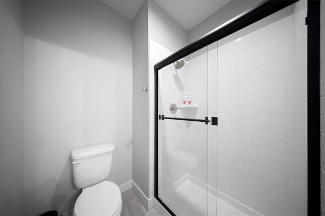 bathroom featuring baseboards, a stall shower, and toilet