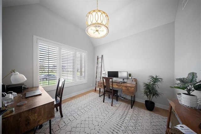 home office featuring baseboards, light wood-style flooring, a chandelier, and vaulted ceiling