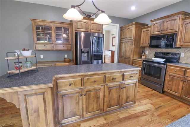 17065 W 162nd St, Olathe, KS 66062 - kitchen with decorative backsplash, appliances with stainless steel finishes, dark countertops, light wood-type flooring, and glass insert cabinets