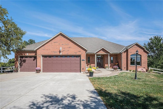 ranch-style house featuring brick siding, an attached garage, driveway, and a front lawn