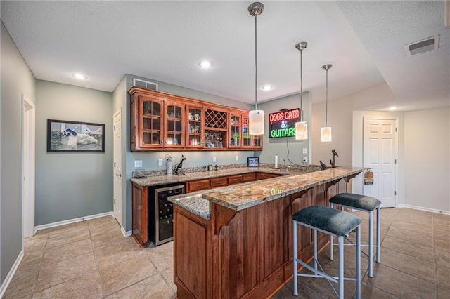 bar featuring wine cooler, baseboards, indoor wet bar, and visible vents