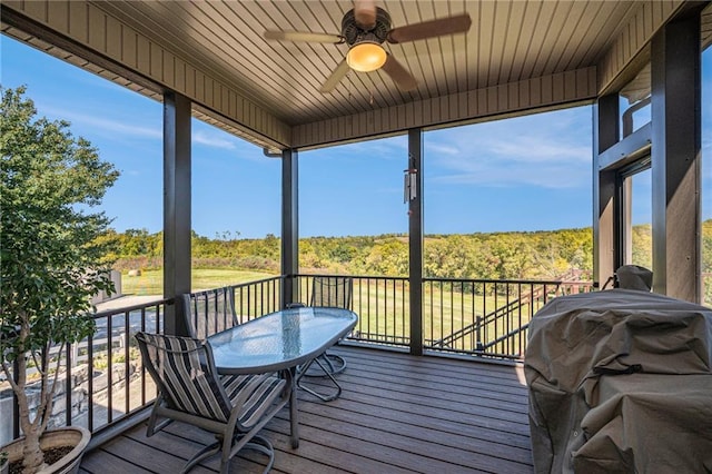 wooden deck featuring a ceiling fan and a grill