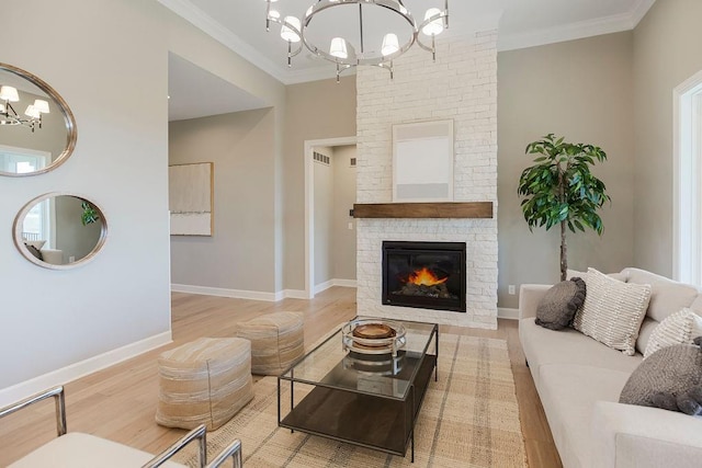 living area with ornamental molding, wood finished floors, a fireplace, baseboards, and a chandelier