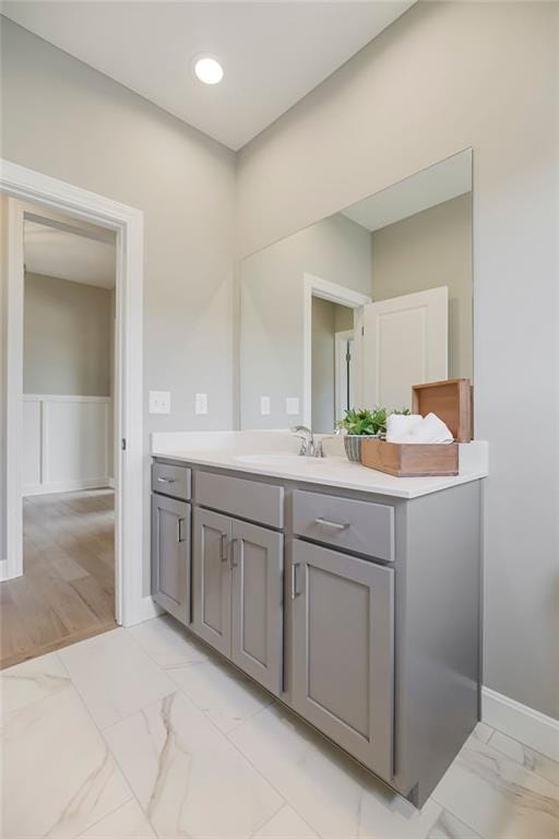bathroom with vanity, baseboards, and marble finish floor