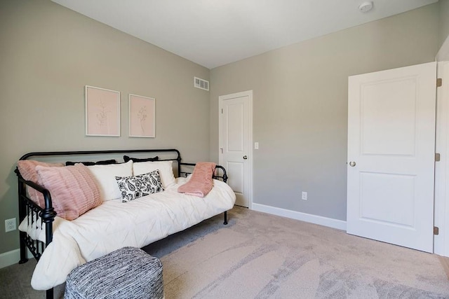 carpeted bedroom featuring baseboards and visible vents