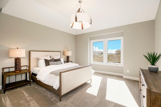 bedroom with baseboards and light colored carpet
