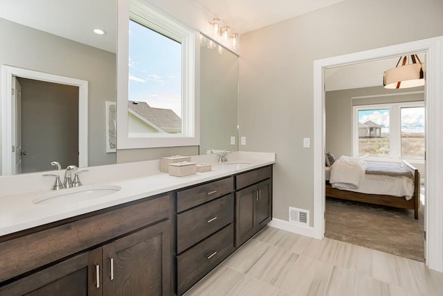 full bathroom featuring double vanity, visible vents, a sink, and ensuite bathroom