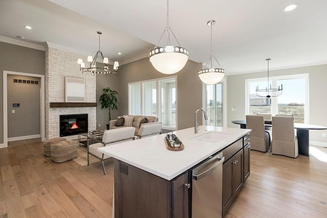 kitchen with crown molding, a sink, a chandelier, and stainless steel dishwasher