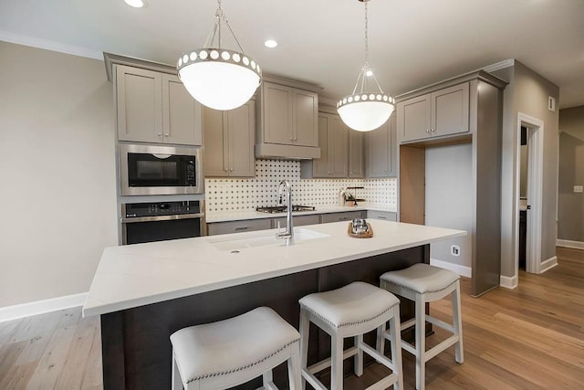 kitchen with baseboards, stainless steel oven, gray cabinets, and built in microwave