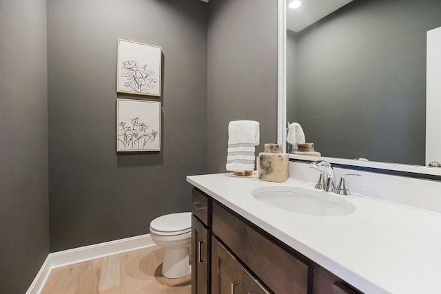 bathroom with vanity, baseboards, and toilet