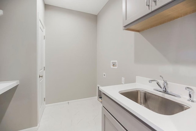 laundry area with cabinet space, a sink, baseboards, hookup for a washing machine, and marble finish floor