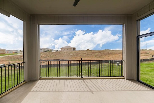 unfurnished sunroom with a ceiling fan