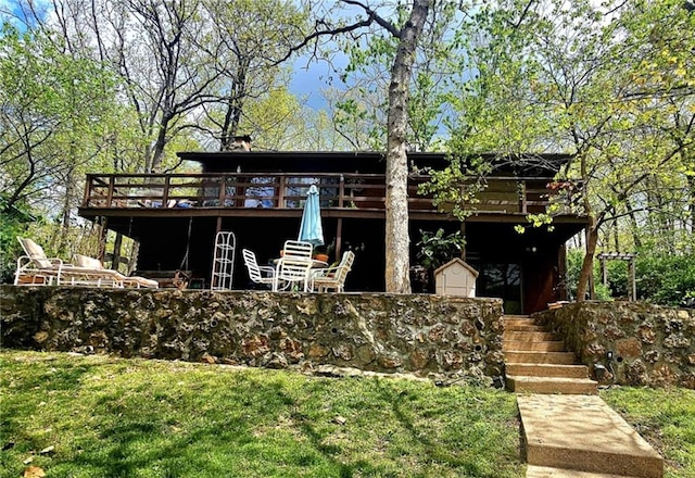 view of front facade featuring stairs, a wooden deck, and a front yard